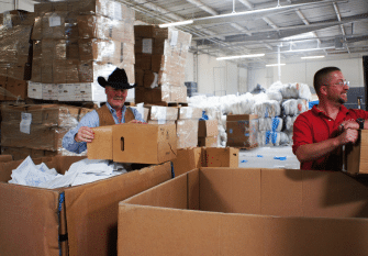 Recycling facility, two men standing in front of cardboard bins
